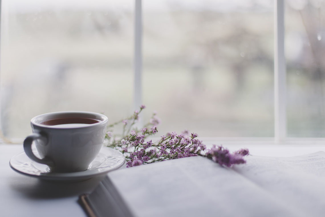 cup of tea, book, flowers in front of window - Simple Anti-Inflammatory Tea